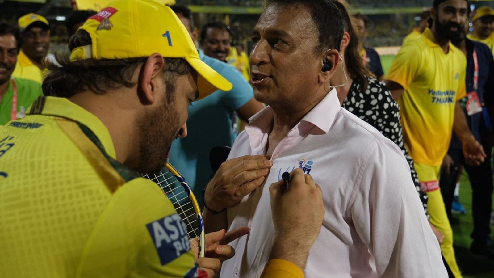 MS Dhoni (L) giving an autograph on Sunil Gavaskar